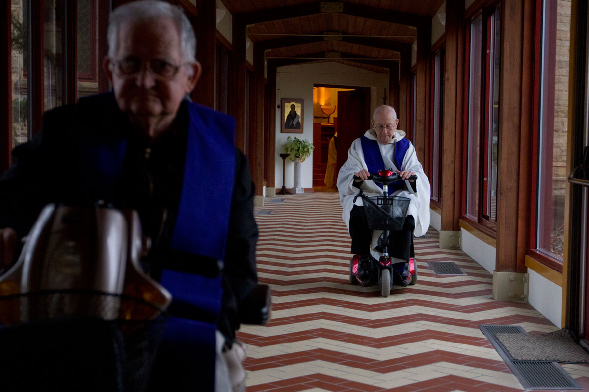 After celebrating Mass, Father Augustine Davis (left) and Father Cletus Miller move through the hallway connecting the Archabbey Church to the cloistered area of the monastery at Saint Meinrad Archebbey in Saint Meinrad, Ind., March 18, 2013. The community of monks begins its day with prayer at 5:30 in the morning followed by breakfast and silent, spiritual reading before Mass at 7:30 a.m.