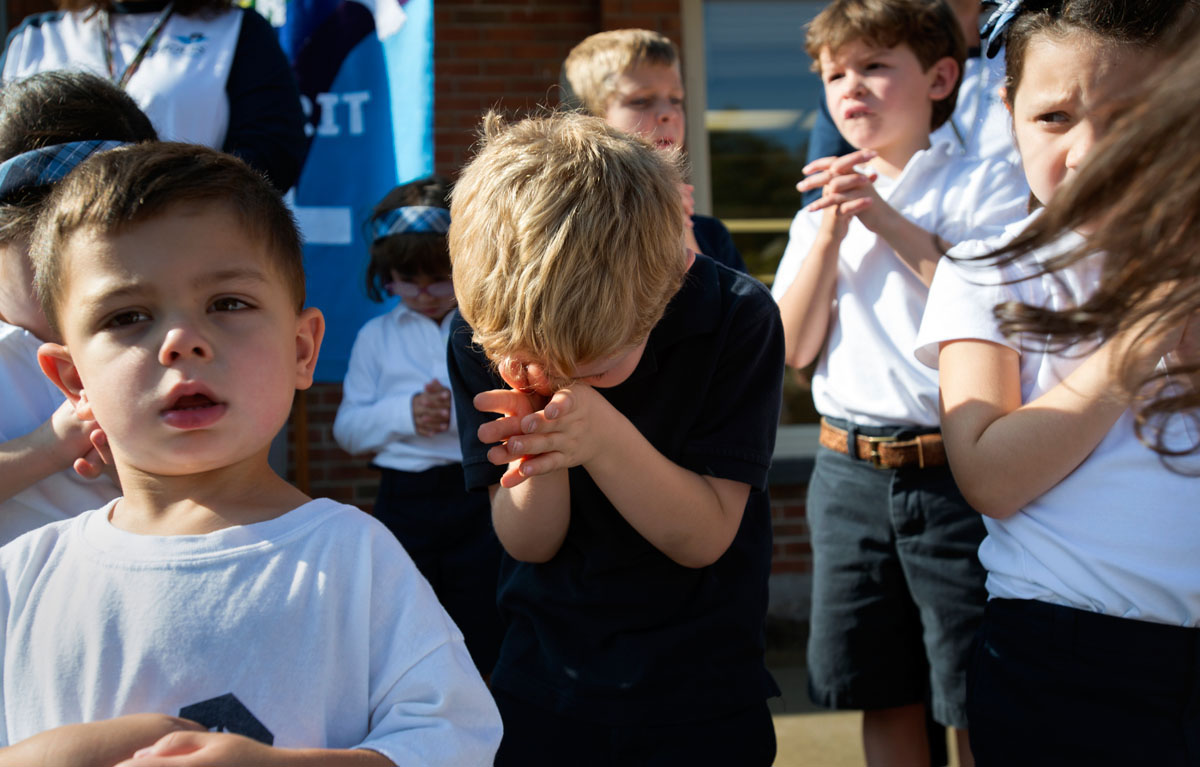 Kindergartner Jackson Hickey takes a prayerful stance while Father Bob Ring gives a blessing over the new Early Learning Center at St. Louis School in Pittsford Sept. 20, 2013.