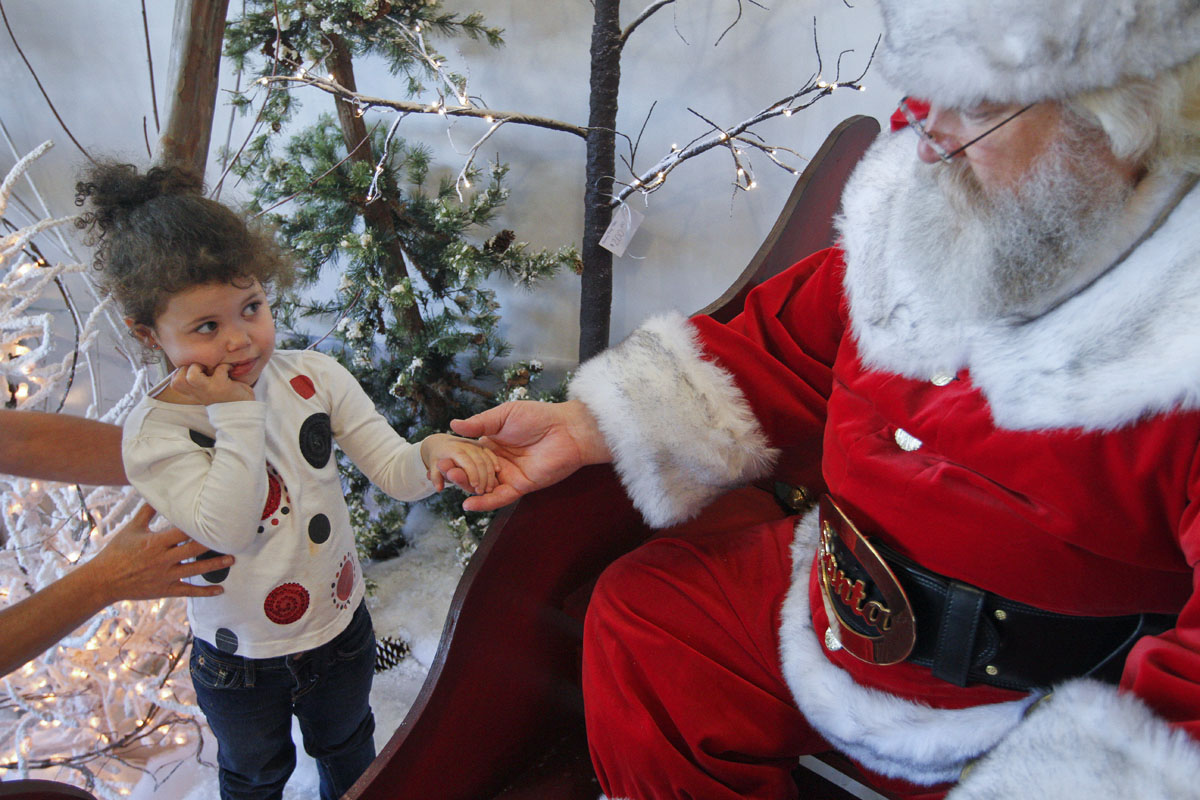 Kinleigh Neal, a 3-year-old from Bowling Green, is encouraged to visit Santa Nov. 10, 2012, at Deemer's Flowers in Bowling Green. Murray McCandless of Elizabethtown played Santa at the store's Christmas open house. I looked in the mirror one day, said 'I'm fat and have a white beard, what am I going to do?' said McCandles, who is in his fifth year playing Santa. 